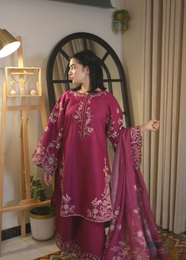Woman wearing a magenta embroidered Pakistani 3 piece suit with floral neckline, embroidered flared sleeves and matching dupatta